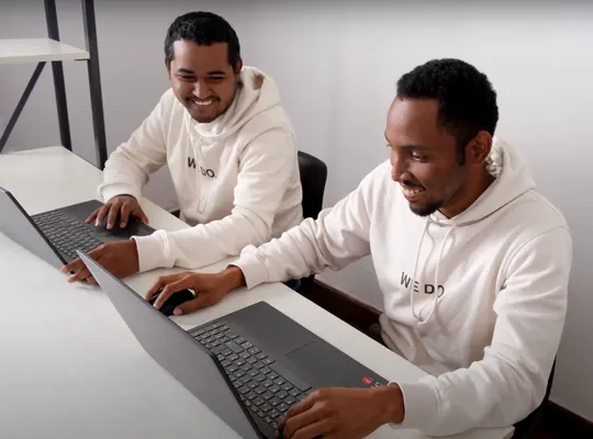 Das Team von Africa GreenTec versammelt vor einem ihrer Solartainer