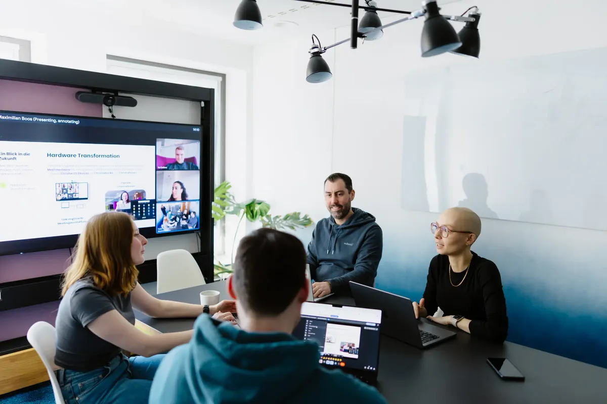 Ein Projektteam plant in einem modernen, hybriden Meeting die Implementierung und Migration neuer Systeme.