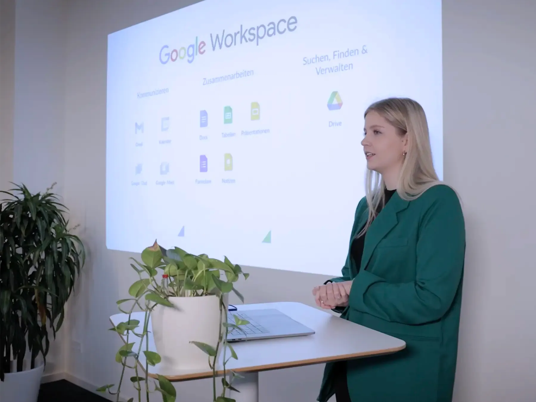 Eine Referentin hält eine Schulung zu Google Workspace und zeigt die verschiedenen Anwendungen auf einer Präsentationsfolie.