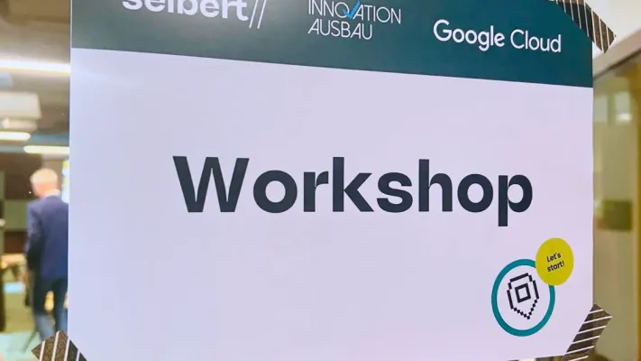 Workshop-Schild des KI-Businessclub BAU mit den Logos von Seibert, Innovation Ausbau und Google Cloud.