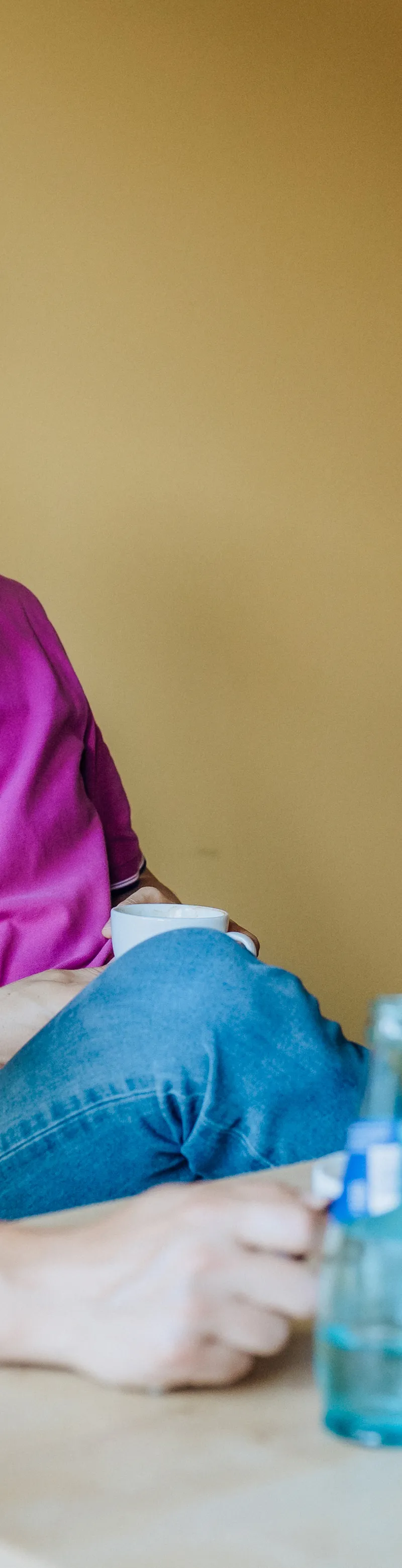 Three men sitting at a table having a discussion with water bottles and sticky notes visible.